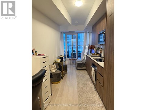 A well-lit kitchen with wooden cabinets and a large window.