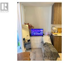 A bedroom with a bed, a desk, and a television displaying a map.