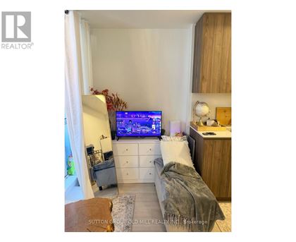 A bedroom with a bed, a desk, and a television displaying a map.