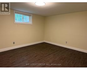Empty room with a window and wooden flooring.