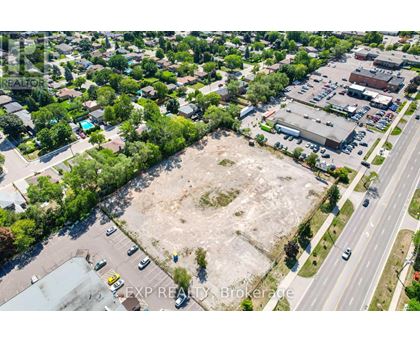 An aerial view of a large empty lot surrounded by buildings and a road.
