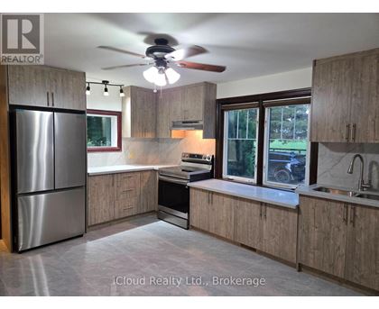 A kitchen with wooden cabinets and a stainless steel refrigerator.