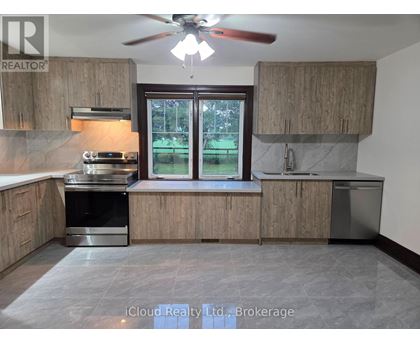 A kitchen with wooden cabinets and a ceiling fan.