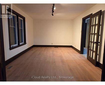 A room with wooden flooring and a ceiling light fixture.