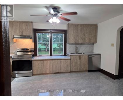 A kitchen with wooden cabinets and a ceiling fan.