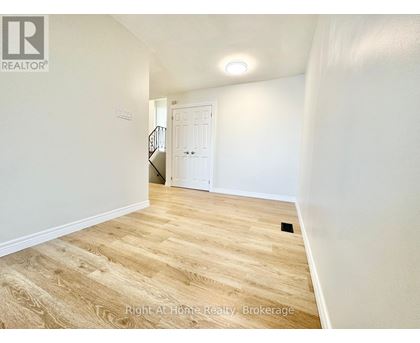 A room with wooden flooring and a white door.
