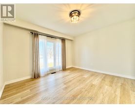 A room with wooden flooring and a sliding glass door.