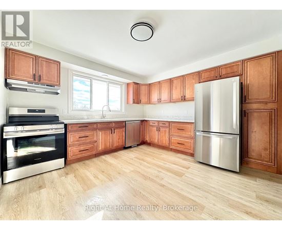 A kitchen with wooden cabinets and a stainless steel refrigerator.