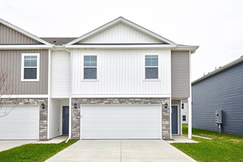 A two-story house with a garage door in the center.