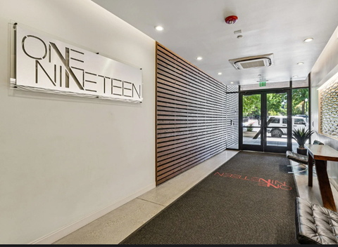 A hallway with a sign that says "ONE NINETEEN" on the wall.
