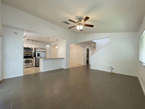A spacious room with a ceiling fan and tiled flooring.