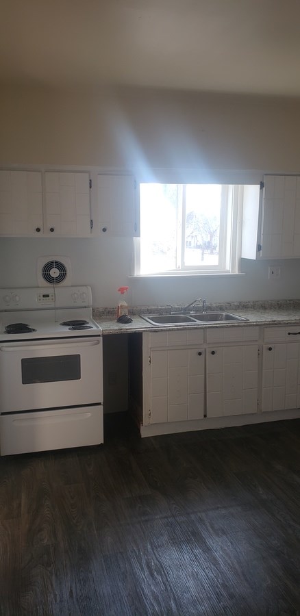 A kitchen with white appliances and cabinets.