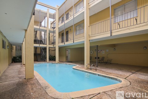 A small indoor pool is surrounded by apartment balconies.