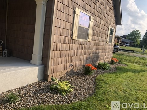 A house with a brown siding and a white window.