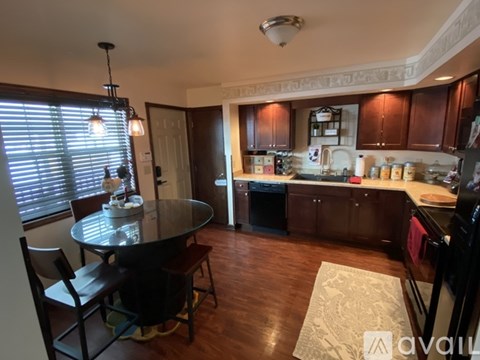 A kitchen with a table and chairs in front of a window.
