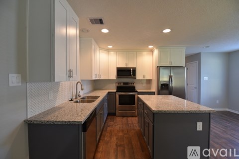 A kitchen with a granite countertop and stainless steel appliances.