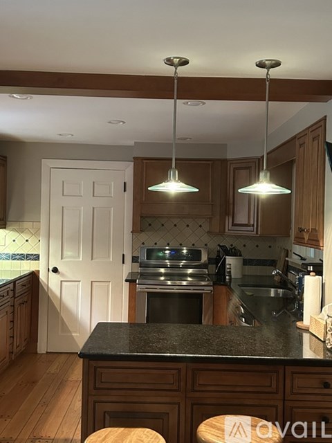 A kitchen with a black countertop and wooden cabinets.
