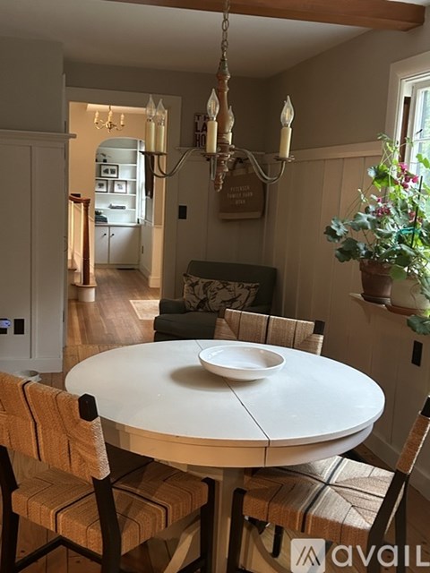 A dining room with a white table and chairs.
