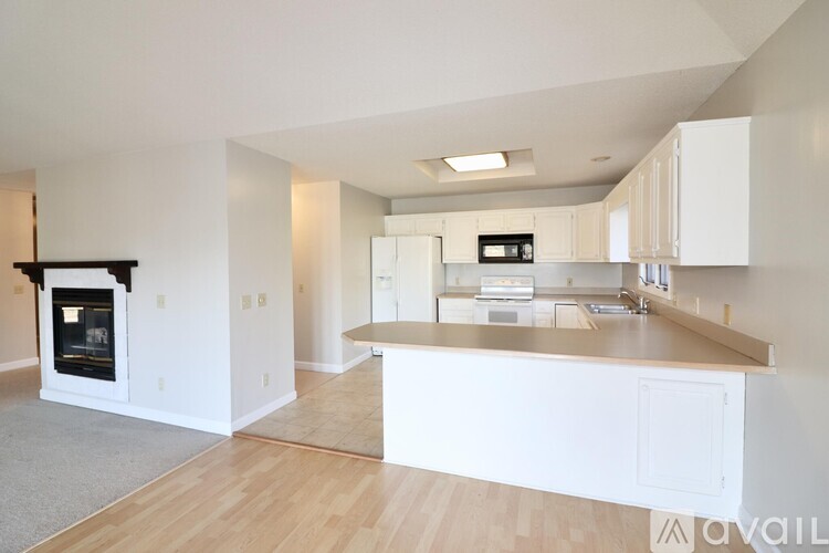 A modern kitchen with white cabinets and a wooden island.