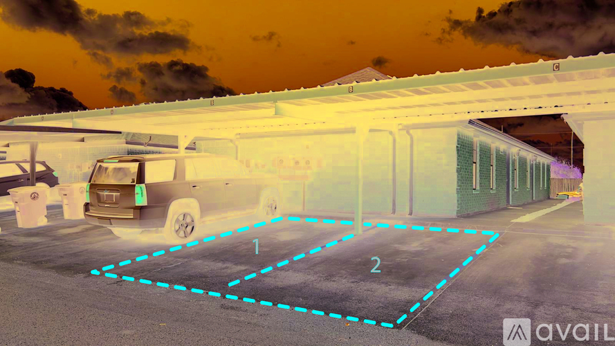 A car is parked in a parking lot with a blue dashed line indicating a parking space.