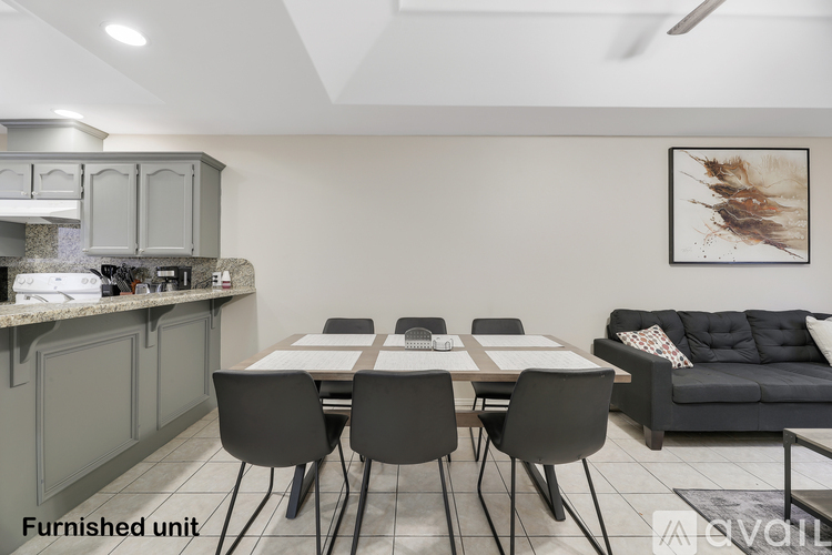 A modern dining area with a table set for six and a couch.
