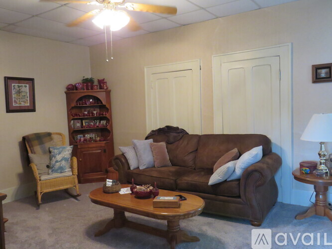 A living room with a brown couch, a wooden chair, and a coffee table.