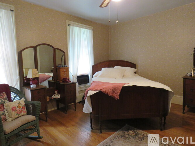 A bedroom with a bed, dresser, and chair.