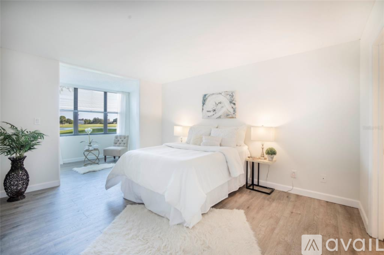 A bedroom with a large bed and a view of the outdoors through a window.