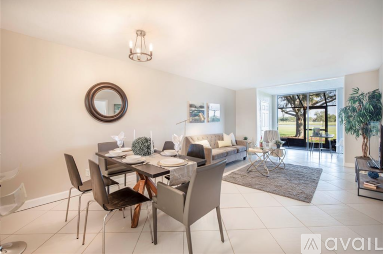A dining room with a round mirror on the wall and a table set for a meal.
