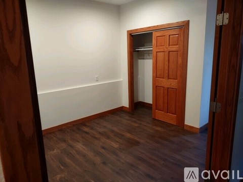 A room with a wooden floor and a wooden door.