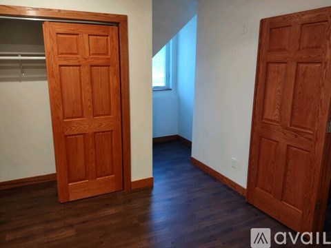Two wooden doors in a room with a white wall and wooden floor.