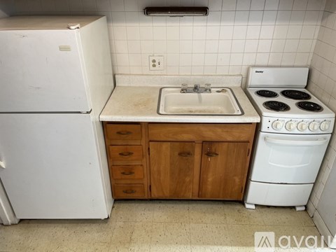 A kitchen with a white fridge, a white stove, and a white sink.