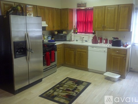 A kitchen with wooden cabinets and a black fridge.