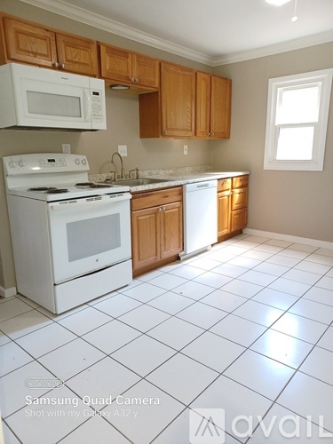 A kitchen with white appliances and wooden cabinets.