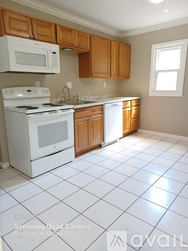 A kitchen with white appliances and wooden cabinets.