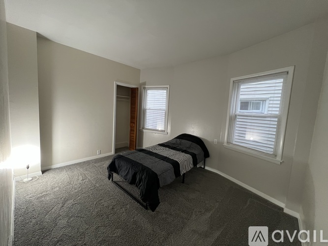 A bedroom with two beds and carpeted flooring.