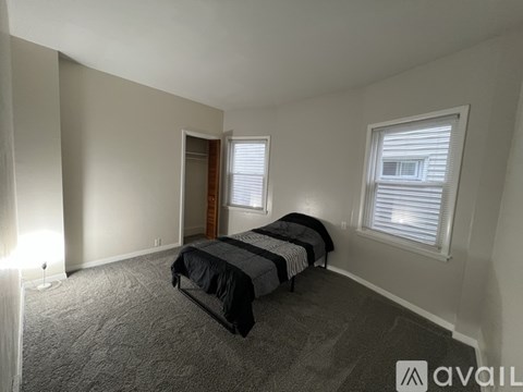 A bedroom with two beds and carpeted flooring.