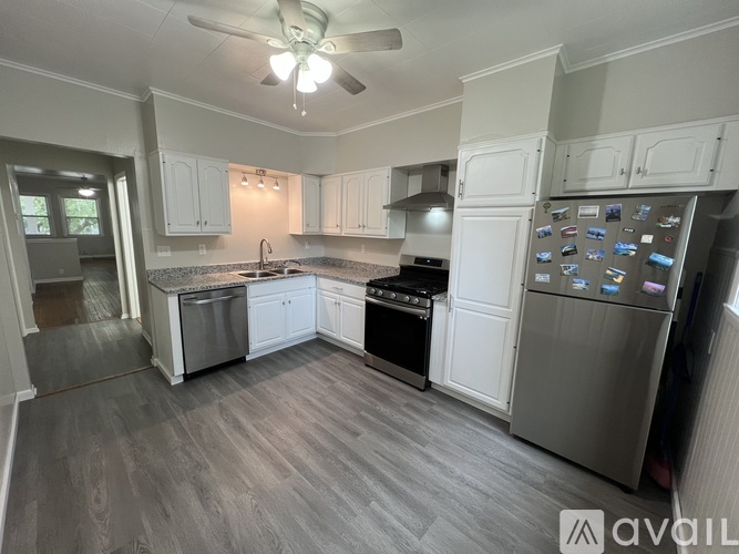 A kitchen with white cabinets and a grey floor.