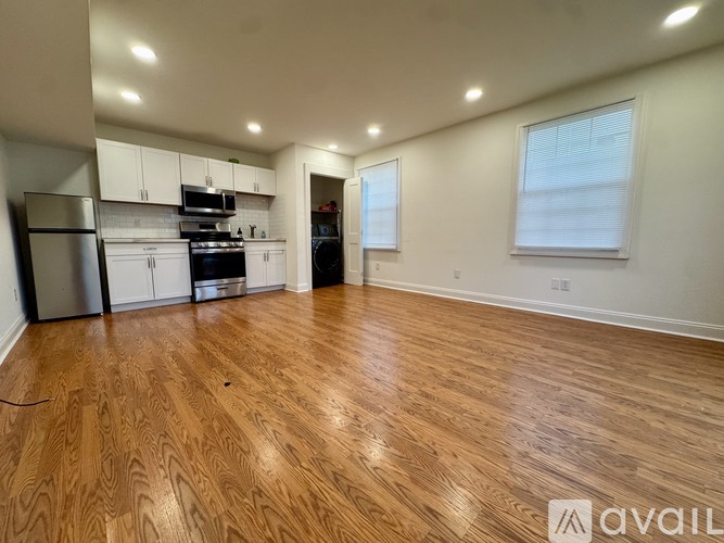 A kitchen with wooden floors and white cabinets.