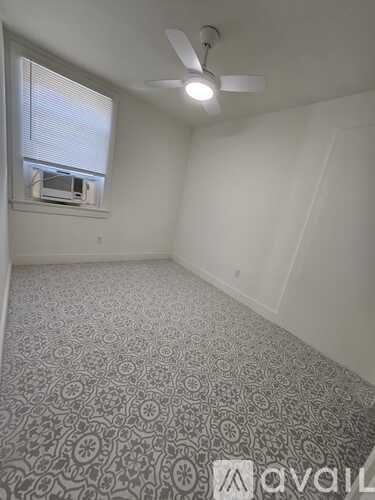 A room with a carpeted floor and a ceiling fan.