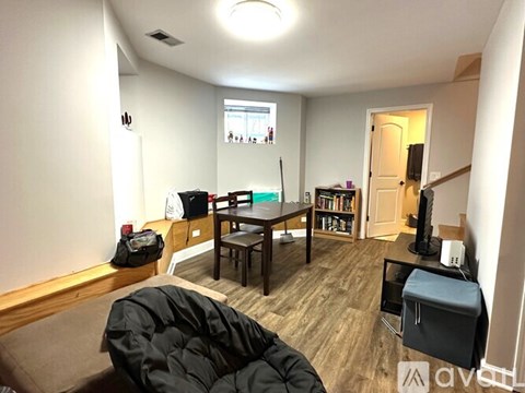 A living room with a black bean bag chair and a wooden coffee table.