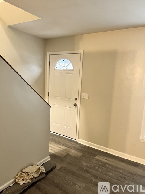 A white door with a glass window is in the middle of a hallway.
