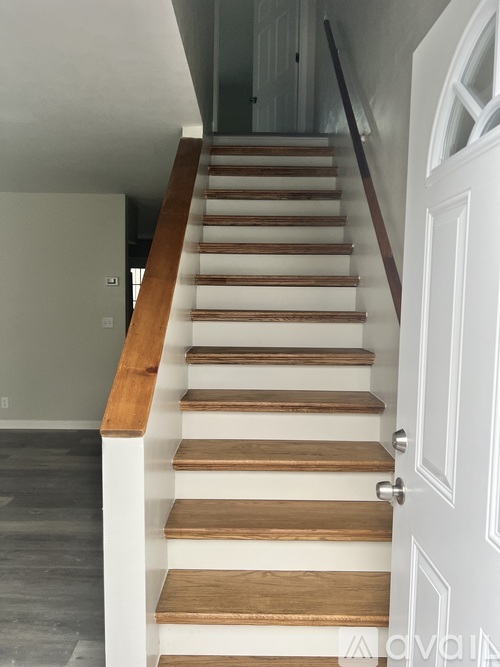 A staircase with white risers and wooden treads.
