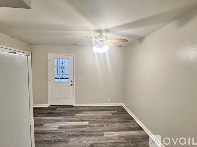 A room with a white door and a ceiling fan.