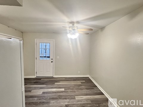 A room with a white door and a ceiling fan.