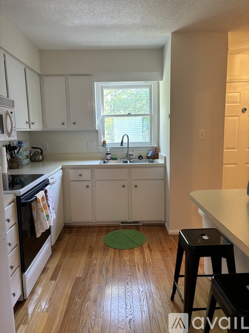 A kitchen with white cabinets and a black stove top oven.