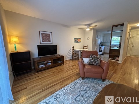 A living room with a brown leather chair and a wooden floor.