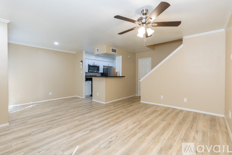 A spacious room with a ceiling fan and lighting fixture.