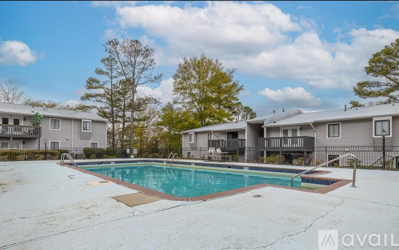 A swimming pool in front of a row of houses.