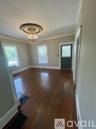 A room with wooden floors and a chandelier.